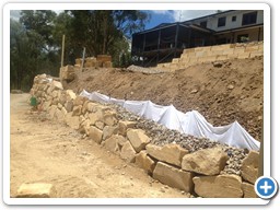 Boulder retaining wall before completion